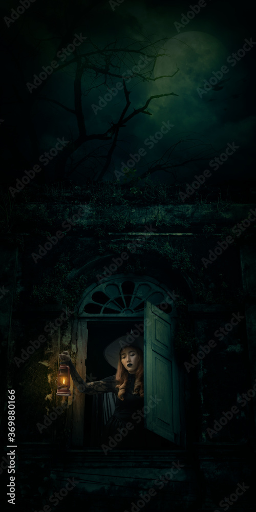 Halloween witch holding ancient lamp standing in ancient window building over dead tree, birds, full moon and spooky cloudy sky, Halloween mystery concept Halloween witch holding ancient lamp standing in ancient window building over dead tree, birds, full moon and spooky cloudy sky, Halloween mystery concept