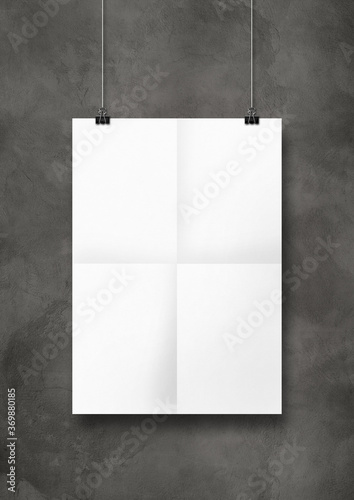 white folded poster hanging on a concrete wall