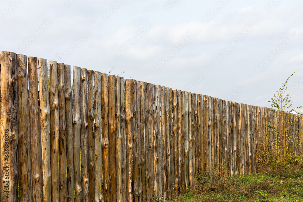 Rural landscape with a wooden fence around the old house Rural landscape with a wooden fence around the old house