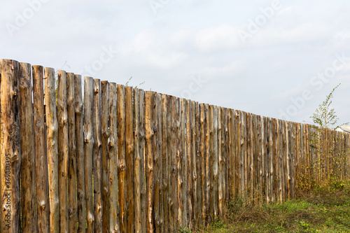 Rural landscape with a wooden fence around the old house