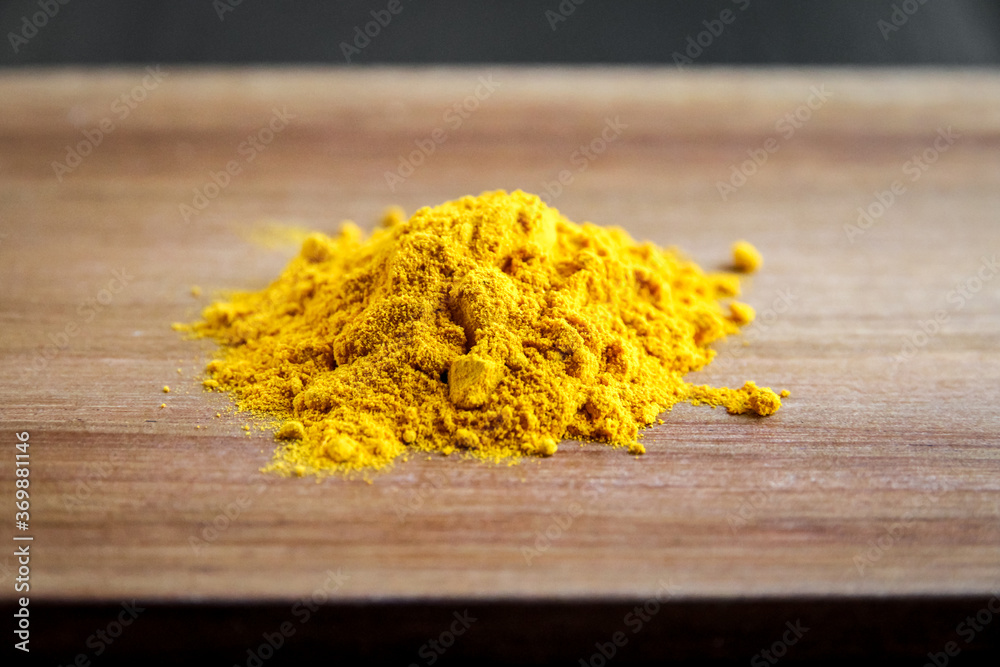 turmeric powder on wooden board turmeric powder on wooden board
