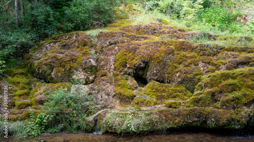 Waterfall at City Rauna, Latvia. River With a Rocky Bottom and Rauna Staburags Cliff. A Unique Rock Form of Nature Through Which the Water Flows Down the Moss and Looks Like It Cries.