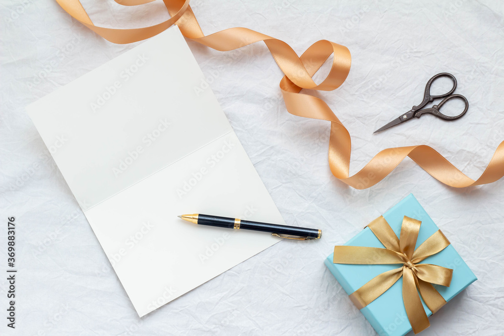 白紙のカードと金色のリボンの青いギフトボックスとボールペンとハサミ Stock Photo Adobe Stock