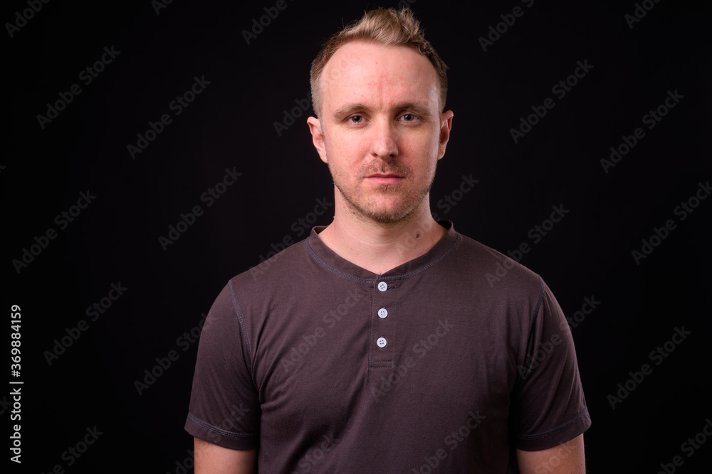 Handsome man with blonde hair against black background Handsome man with blonde hair against black background
