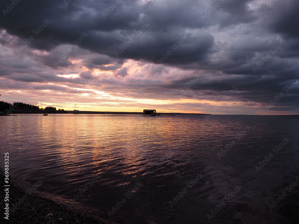 Sunset, summer, beautiful clouds at sunset. Thunderous sunset. Pier on the big Kama river. Ural, Russia, Perm Territory, Elovo. Sunset, summer, beautiful clouds at sunset. Thunderous sunset. Pier on the big Kama river. Ural, Russia, Perm Territory, Elovo.