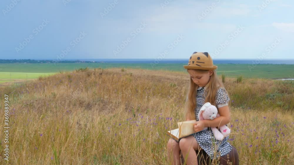 Vidéo Stock Child girl in a straw hat and dress sitting on vintage ...