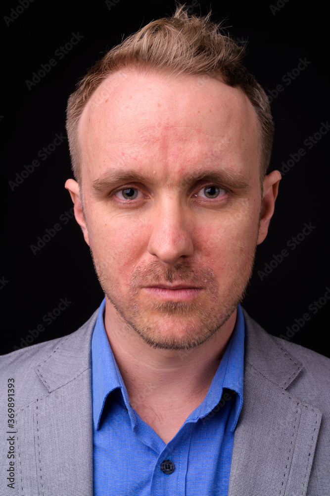 Fototapeta premium Handsome businessman with blonde hair against black background
