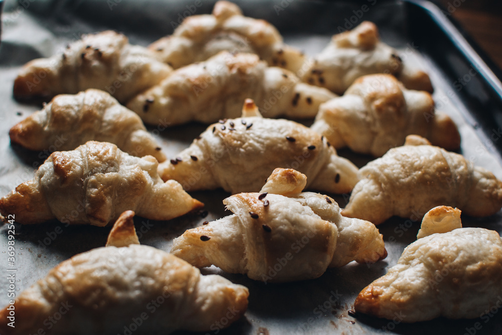 Freshly baked homemade croissants on wooden table, selective focus Fresh out of the oven. Breakfast or brunch concept.