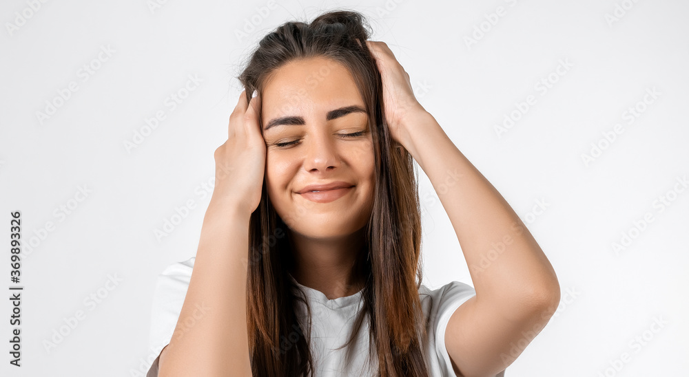 Pretty carefree modern girl with long chestnut hair holding to her head or touching hair. Isolated on white background. Emotions, expressions, hairstyle and people concept. Pretty carefree modern girl with long chestnut hair holding to her head or touching hair. Isolated on white background. Emotions, expressions, hairstyle and people concept.
