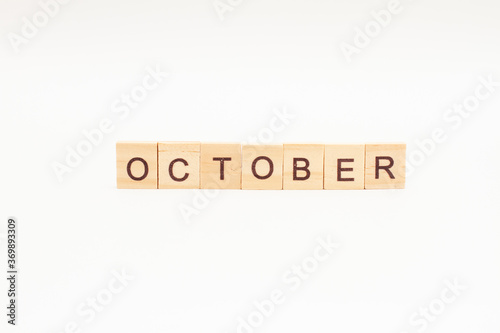 Word OCTOBER made of wooden blocks on white background. Month of year