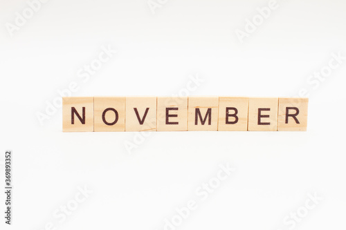 Word NOVEMBER made of wooden blocks on white background. Month of year. Calendar. Last month of autumn