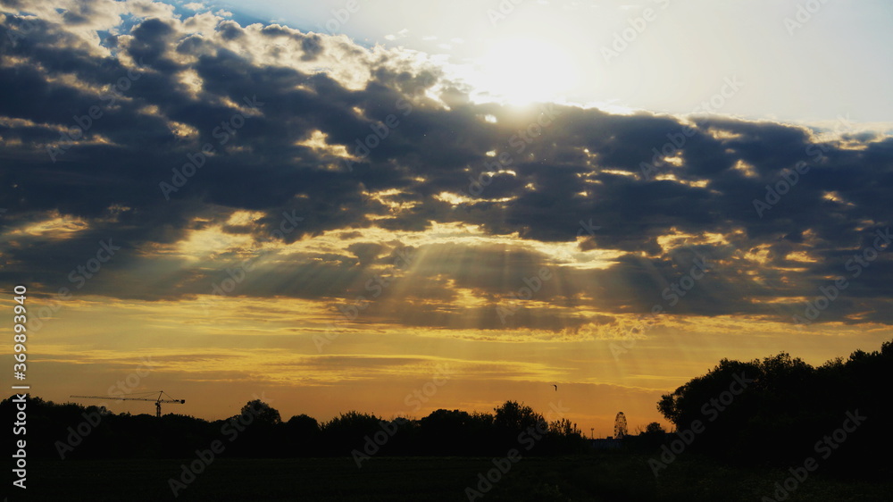 Fototapeta premium sun rays from clouds in the evening field