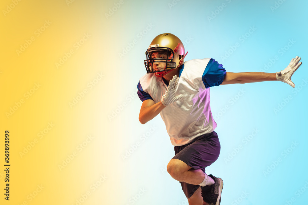Support. American football player isolated on gradient studio background in neon light. Professional sportsman during game playing in action and motion. Concept of sport, movement, achievements.