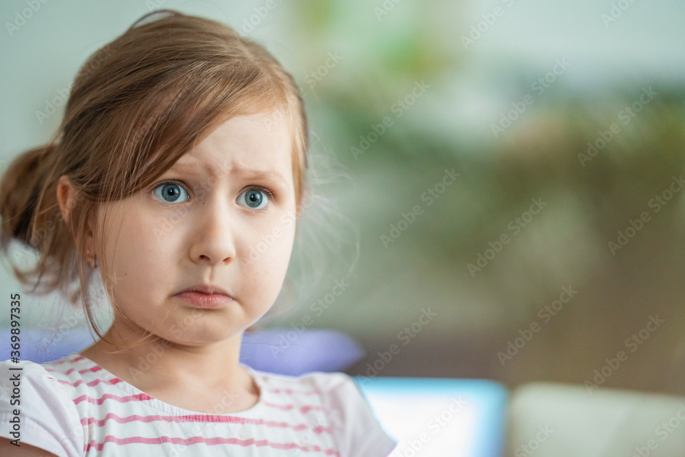 discontented little girl looks indignantly with big eyes on blurred background discontented little girl looks indignantly with big eyes on blurred background
