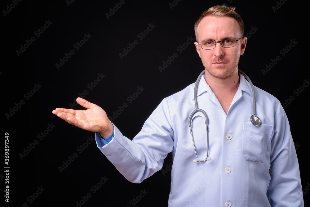 Handsome man doctor with blonde hair against black background Handsome man doctor with blonde hair against black background