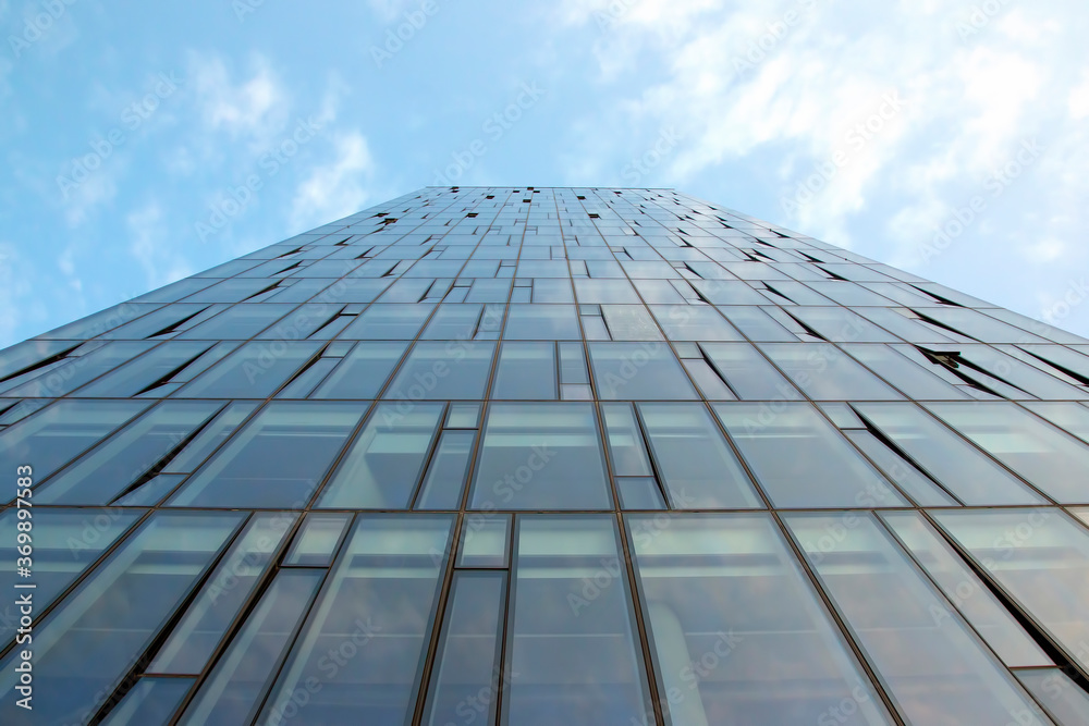 Glass facade of a modern multi-storey building against the sky Glass facade of a modern multi-storey building against the sky
