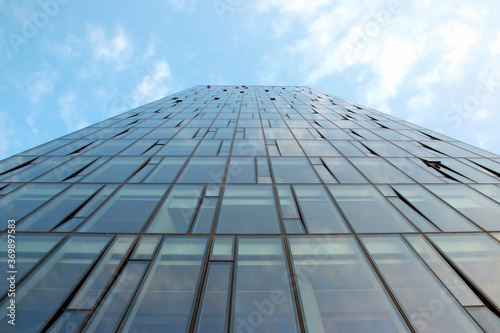 Glass facade of a modern multi-storey building against the sky
