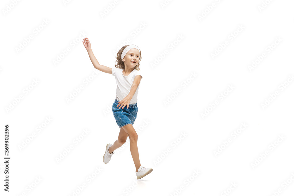 Lightness. Happy kids, little and emotional caucasian girl jumping and running isolated on white background. Look happy, cheerful, sincere. Copyspace for ad. Childhood, education, happiness concept.