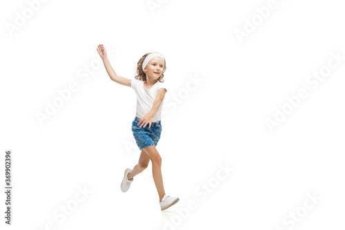 Lightness. Happy kids, little and emotional caucasian girl jumping and running isolated on white background. Look happy, cheerful, sincere. Copyspace for ad. Childhood, education, happiness concept.