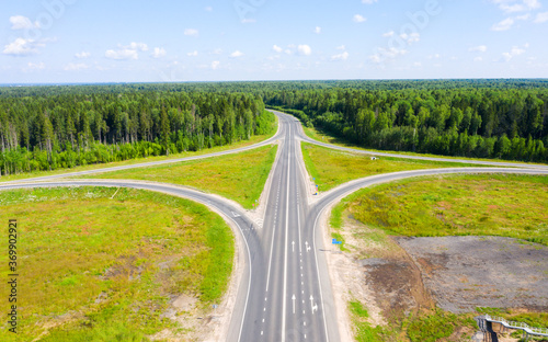 Clover or daisy, a simple and cheap type of road junction. Aerial view of highway road junction in the in the Kostroma region, Russia.