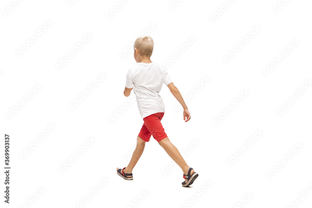 Target. Happy kids, little and emotional caucasian boy jumping and running isolated on white background. Look happy, cheerful, sincere. Copyspace for ad. Childhood, education, happiness concept.