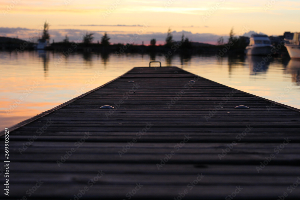 Fototapeta premium Wooden pier stretching into the lake vesijärvi at sunset. Lahti. Finland.