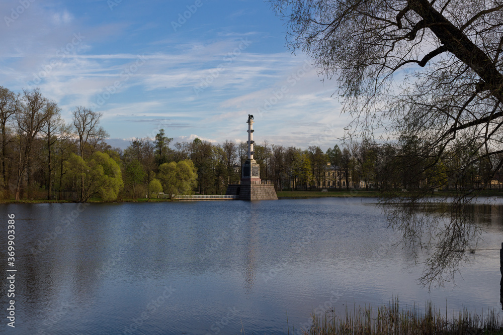 The Chesma column, located in the Big lake of the Catherine Park, is surrounded by trees. Against the blue sky.