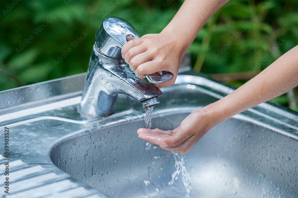 Foto Stock Baby try to turn off water faucet but water still leak. A