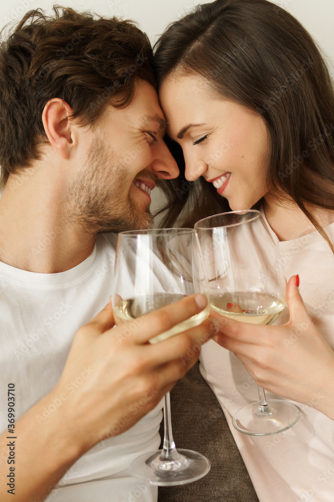 Young couple drinking white wine and relaxing at home Young couple drinking white wine and relaxing at home