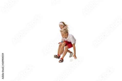 Playing. Happy kids  little emotional caucasian boy and girl jumping and running isolated on white background. Look happy  cheerful  sincere. Copyspace for ad. Childhood  education  happiness concept.