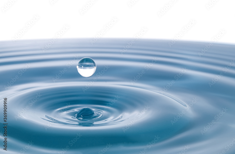Water droplets fall down closely into the dark blue water, making it the perfect center in nature. Isolated on white background Water droplets fall down closely into the dark blue water, making it the perfect center in nature. Isolated on white background