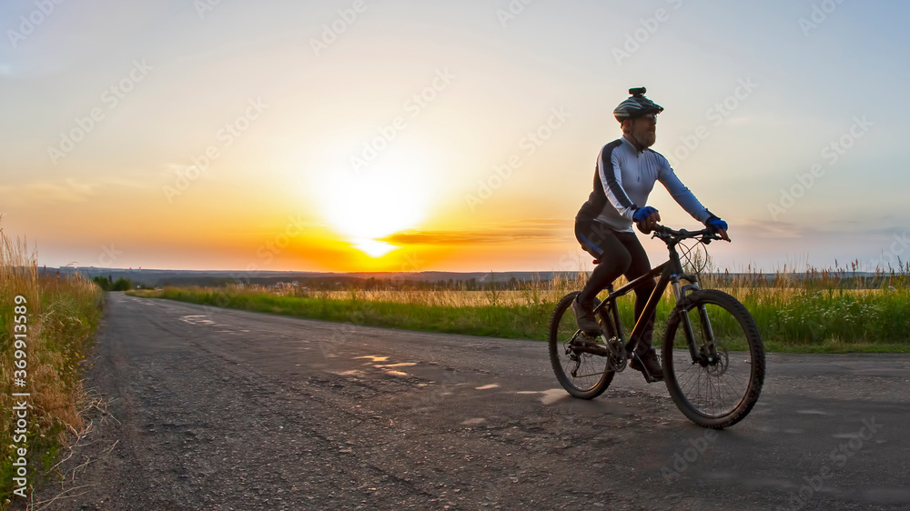 cyclist rides on the road into the sunset. sports and hobbies. outdoor activities