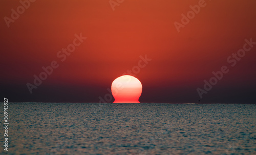 Fototapeta Naklejka Na Ścianę i Meble -  Beautiful sunrise at sea. The sun rises from the sea. The calm sea