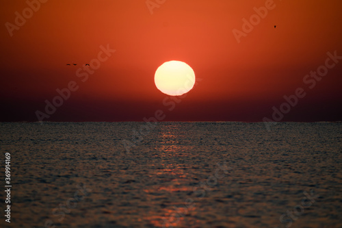 Beautiful sunrise at sea. The sun rises from the sea. The calm sea