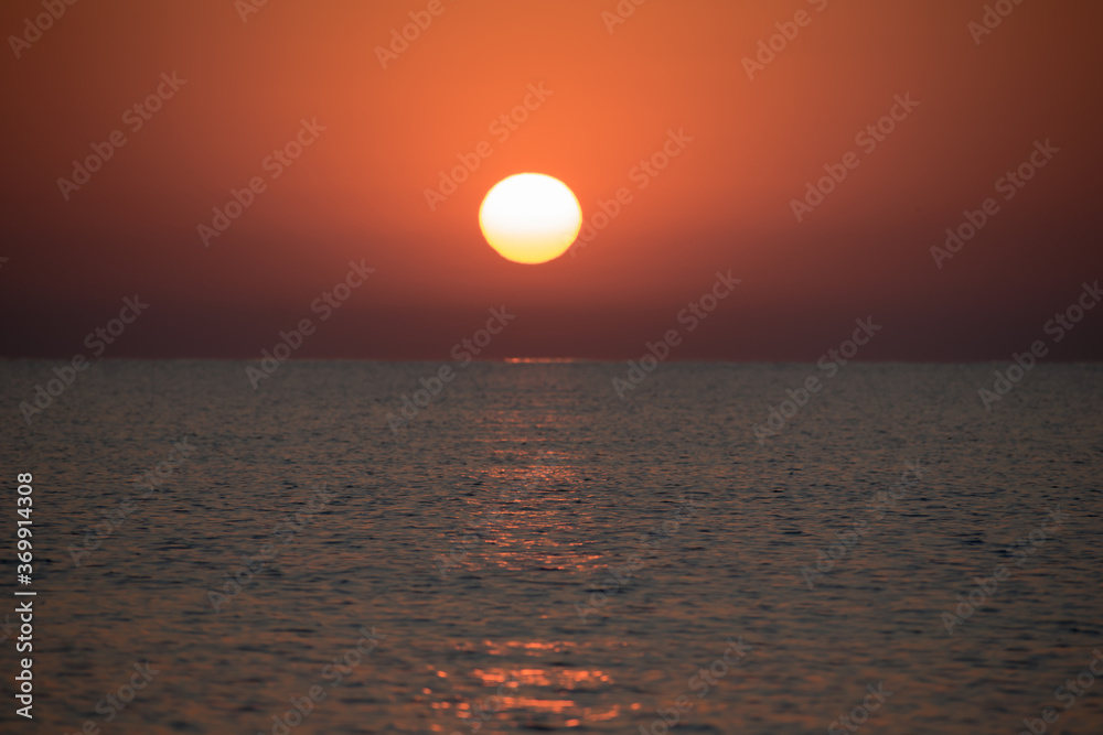 Beautiful sunrise at sea. The sun rises from the sea. The calm sea