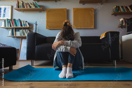 Frustrated and tired spoprty woman crying alone at home. Workout fail and lack of motivation concept. photo