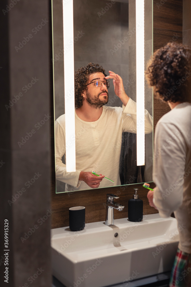 Obraz premium Man performing personal hygiene routine in bathroom