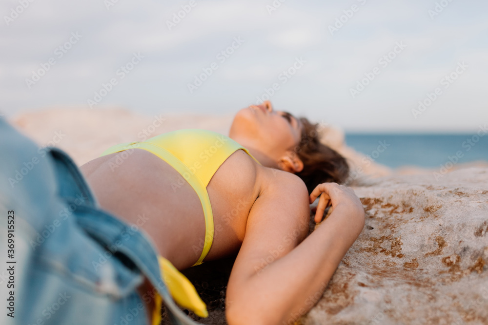 Fototapeta premium Woman in the beach wearing yellow swimsuit
