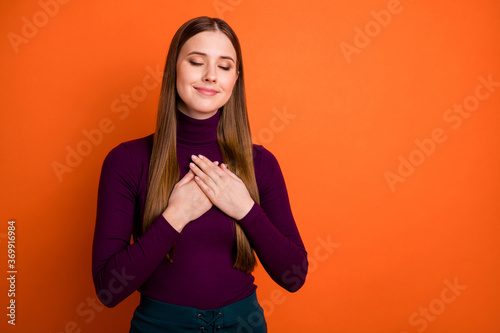 Photo of positive cheerful girl put palms chest enjoy self harmony pledge close eyes wear good look jumper isolated over vibrant color background © deagreez