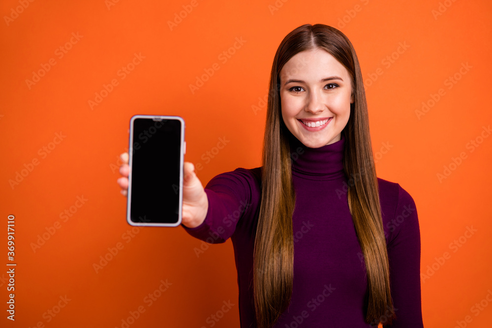 Photo of positive cheerful girl advertise new device product recommend suggest select smart phone wear good look jumper isolated over vivid color background Photo of positive cheerful girl advertise new device product recommend suggest select smart phone wear good look jumper isolated over vivid color background