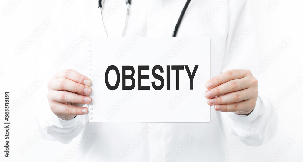 Doctor holding a card with text Obesity medical concept Doctor holding a card with text Obesity medical concept