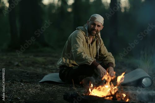 tourist bonfire huntsman, a man in the taiga basking in the fire