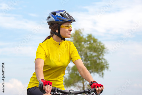 beautiful and happy girl cyclist rides a bicycle on the road in nature. Healthy lifestyle and sports. Leisure and hobbies