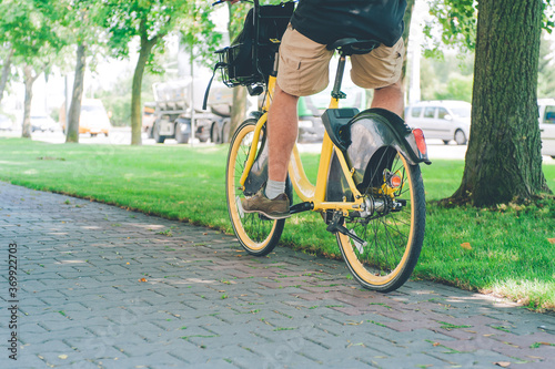 A man rides a yellow rented bike.