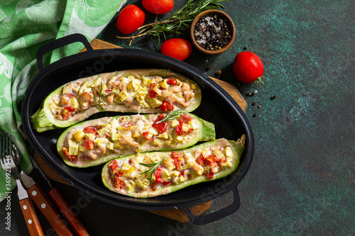 Healthy food. Baked zucchini stuffed with meat and tomatoes in a cast iron pan. Top view flat lay background. Copy space.