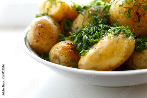 Fotografie Young round fried potatoes, sprinkled with finely chopped dill