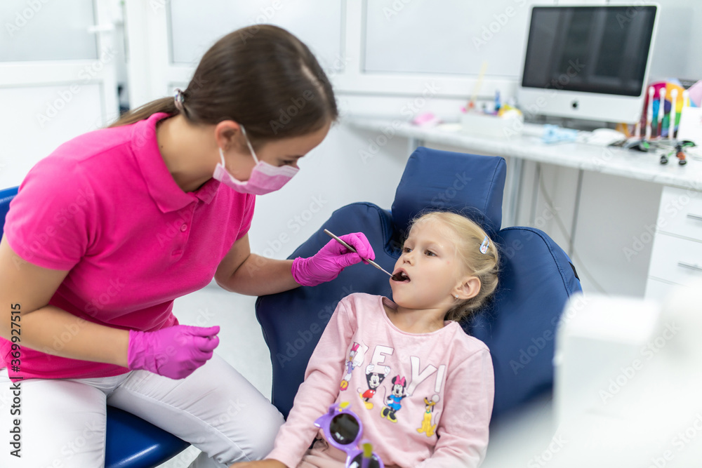 Teeth checkup at dentist's office. Dentist examining girls teeth in the dentists chair. Teeth checkup at dentist's office. Dentist examining girls teeth in the dentists chair.