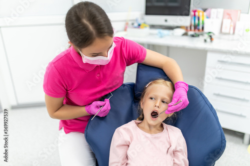 Obraz na płótnie Little girl sitting in the dentists office at teeth check