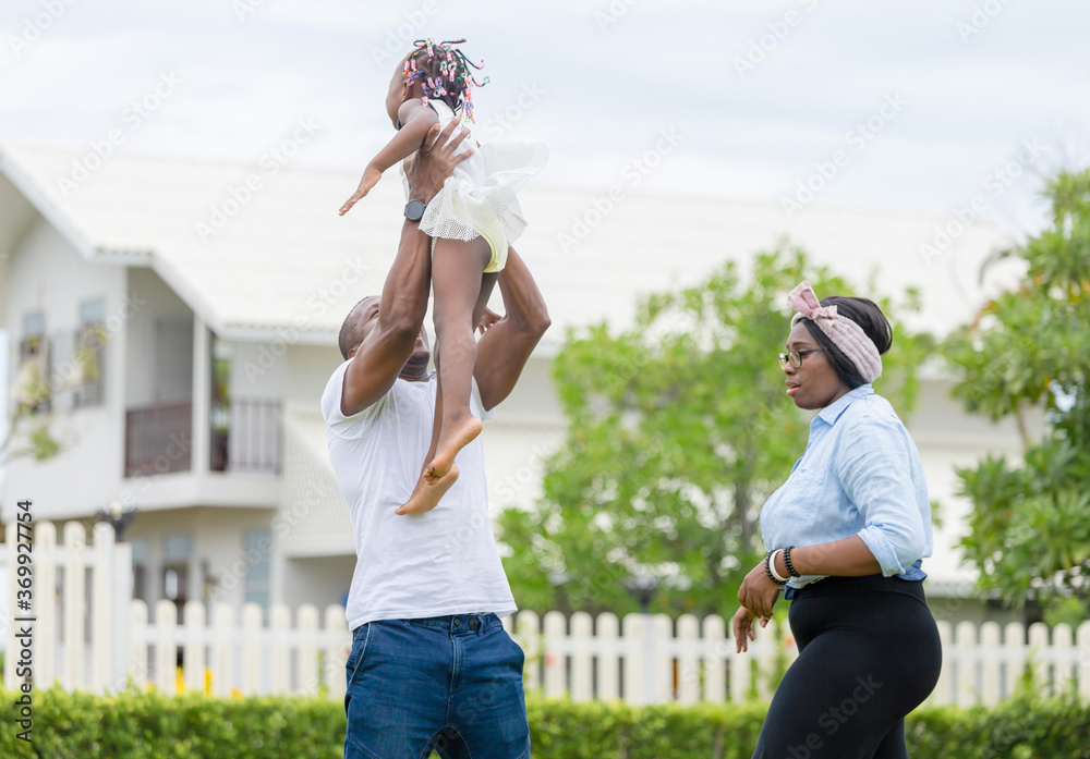 Obraz premium Happy father mother and daughter playing together outdoor, Cheerful african american family enjoying in the park, Happiness family concepts
