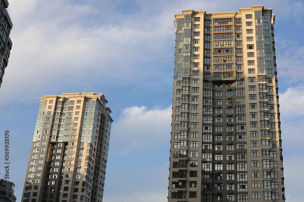 Fototapeta premium Scenic view of contemporary residential houses on a cloudy day. True modern cityscape of the Ukrainian capital. Design of contemporary build in big city. Real urban style of residential building.